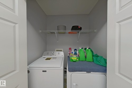 Dedicated laundry area featuring a white top-load washing machine and white front-load dryer - 41 5102 30 Avenue, Beaumont, AB 