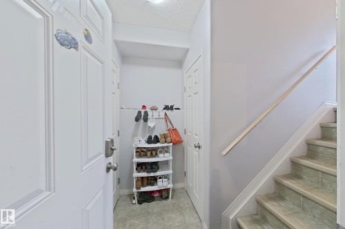 Entryway featuring a white paneled door, light-toned wall paint, and tile flooring - 41 5102 30 Avenue, Beaumont, AB 