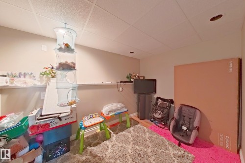 Finished interior space featuring a drop ceiling with recessed lighting, light-toned wall paint, and a low shelf - 41 5102 30 Avenue, Beaumont, AB 