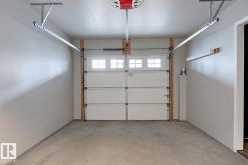 Finished garage interior with painted walls and a concrete floor - 41 5102 30 Avenue, Beaumont, AB 