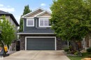 Two-story residence featuring dark siding with stone accents and a prominent two-car garage - 1507 Wates Place Sw, Edmonton, AB 