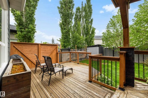 Expansive wood-finish deck featuring a privacy screen, wood-finish railing with black balusters, and a built-in planter box - 1507 Wates Place Sw, Edmonton, AB 
