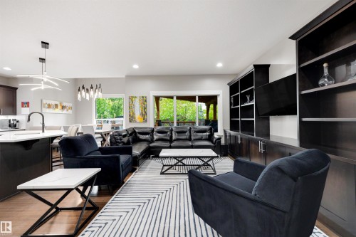Living area featuring built-in cabinetry and shelving, recessed lighting, and wood-finish flooring - 1507 Wates Place Sw, Edmonton, AB 