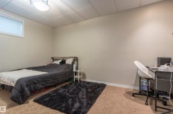 Room featuring light-toned walls, patterned carpeting, and white baseboards - 