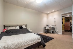 Bedroom featuring a textured ceiling, recessed lighting, and neutral-toned walls - 