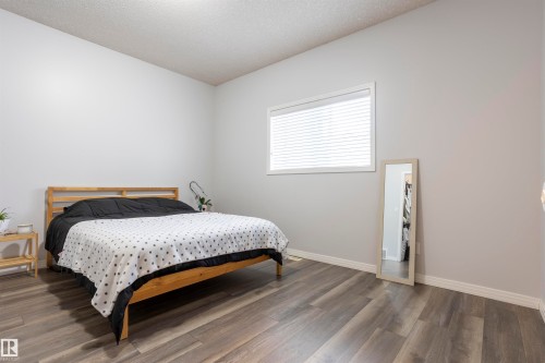 Spacious room featuring wood-finish flooring, light grey painted walls, a white window frame, and white baseboards - 1441 Highwood Boulevard, Devon, AB 