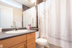 Bathroom featuring a wood-finish vanity with an integrated sink and chrome faucet - 