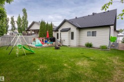 Expansive backyard featuring a manicured lawn, a raised wooden deck, and a full privacy fence - 
