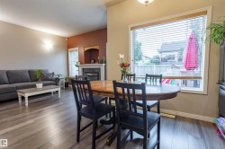 Spacious interior featuring wood-finish flooring, a contemporary fireplace with a mantel, and a large window with blinds - 