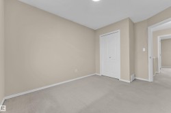 Neutral-toned room with light carpet flooring - 