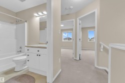 Full bathroom featuring a white vanity with a light-colored countertop, an integrated sink, and a combination tub and shower - 