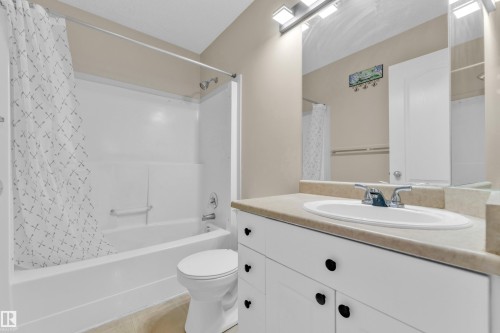 Bathroom vanity featuring a light-colored countertop with an integrated sink and chrome faucet - 3134 30 Avenue Nw, Edmonton, AB 