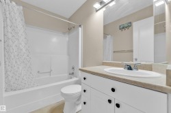 Bathroom vanity featuring a light-colored countertop with an integrated sink and chrome faucet - 