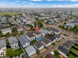 Aerial perspective showcasing a residential neighborhood with detached homes, each featuring individual driveways and pitched roofs - 