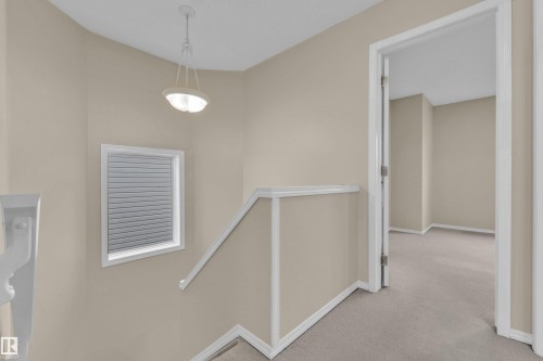 Upper-level landing with neutral wall paint, white trim, and light-toned carpeting - 3134 30 Avenue Nw, Edmonton, AB 