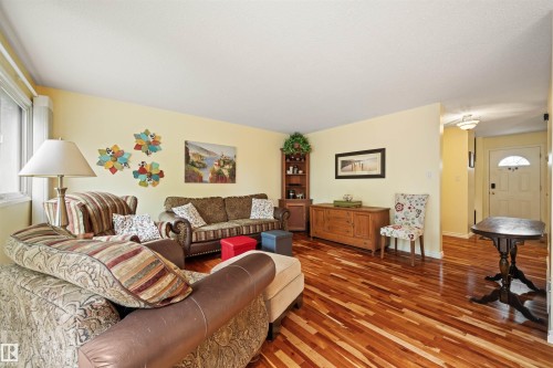 Bright living room featuring wood-finish flooring and a large window - 31 Royal Road, Edmonton, AB 