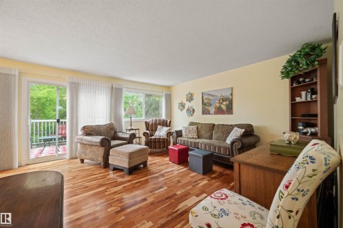 Hardwood flooring throughout, with a sliding glass door opening to an outdoor balcony - 31 Royal Road, Edmonton, AB 