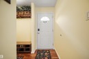 Entryway with a white paneled door featuring an arched window, hardwood flooring, and light-toned wall paint - 31 Royal Road, Edmonton, AB 