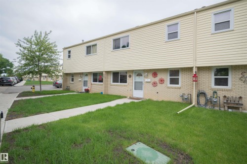 Multi-unit residential building featuring light-colored siding and brick facade - 31 Royal Road, Edmonton, AB 