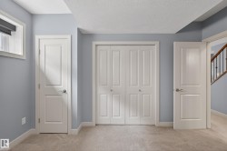 Neutral-toned carpeted flooring with light blue wall paint and white trim - 