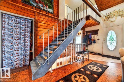 Open-tread staircase with carpeted steps and metal railing - 140 50047 Rge Rd 244, Rural Leduc County, AB 
