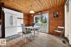 Kitchen area featuring wood-finish flooring, plank wood ceiling, and panel wood walls - 