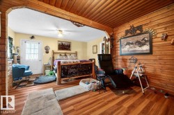 Interior space featuring wood-finish flooring, a log-style accent wall, and a log-style ceiling - 