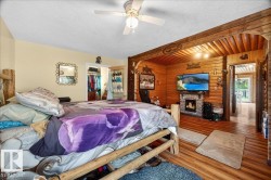 Accent wall featuring horizontal wood paneling and a stone-clad fireplace with hearth - 