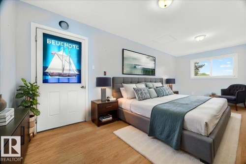 Spacious room featuring wood-finish flooring, light blue wall paint, and a large window - 140 50047 Rge Rd 244, Rural Leduc County, AB 