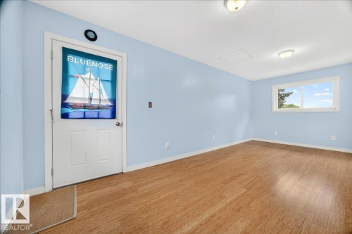 Room featuring wood-finish flooring, light blue walls, and white trim - 140 50047 Rge Rd 244, Rural Leduc County, AB 