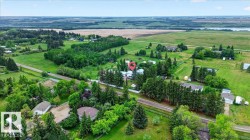 Expansive property featuring a mix of mature trees, open green spaces, and cultivated fields - 