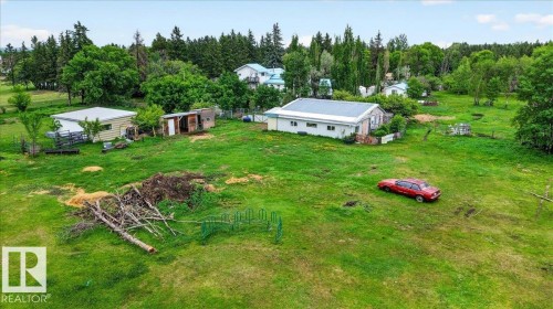 Expansive grassy property featuring multiple outbuildings, mature trees, and natural landscaping - 140 50047 Rge Rd 244, Rural Leduc County, AB 