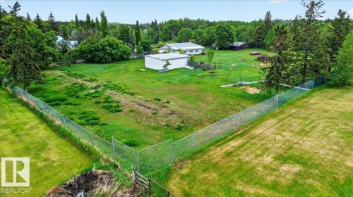 Expansive green space featuring chain-link fencing, mature trees, and outbuildings - 140 50047 Rge Rd 244, Rural Leduc County, AB 