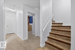 Staircase featuring tile treads with wood-finish nosing and a white handrail - 