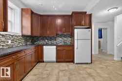 Kitchen featuring wood cabinetry, stone-finish countertops, and a mosaic tile backsplash - 