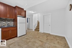 Kitchenette featuring wood cabinetry, integrated sink, and a mosaic tile backsplash - 