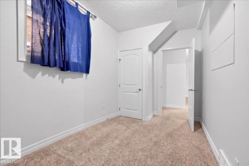 Neutral tone carpet flooring, white painted walls, and white trim throughout - 10958 88 Avenue, Edmonton, AB 