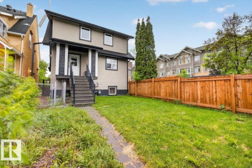 Two-story home with light-toned siding, dark trim, and a white front door - 10958 88 Avenue, Edmonton, AB 