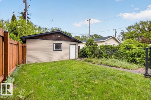 Detached garage with horizontal siding, a private entry door, and a single window - 10958 88 Avenue, Edmonton, AB 