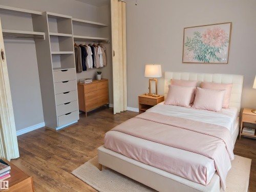Bedroom featuring wood-finish flooring and a built-in closet organization system - 9443 75 Street, Edmonton, AB 
