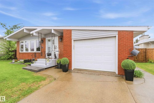 Brick and siding exterior featuring a single-car garage, concrete driveway, and front entryway with steps - 11431 144 Avenue, Edmonton, AB 