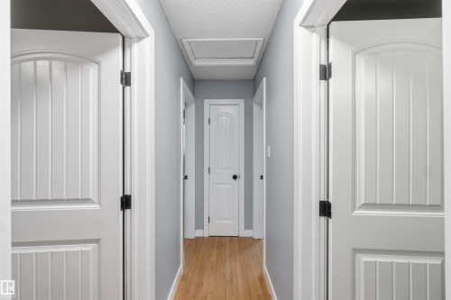 Hallway with light wood-finish flooring, light gray walls, and white trim - 11431 144 Avenue, Edmonton, AB 