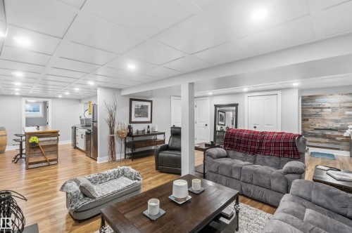 Expansive finished basement featuring wood-finish flooring, recessed lighting, and a coffered ceiling - 11431 144 Avenue, Edmonton, AB 