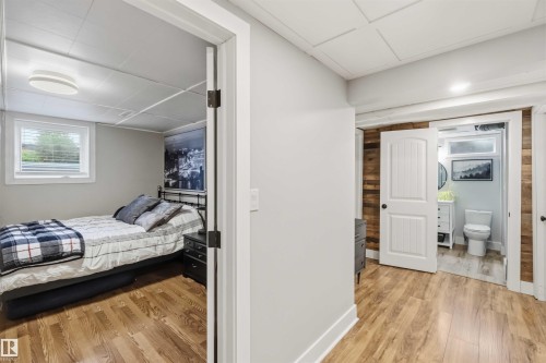 Hardwood-finish flooring in a bright hallway and adjacent bedroom - 11431 144 Avenue, Edmonton, AB 