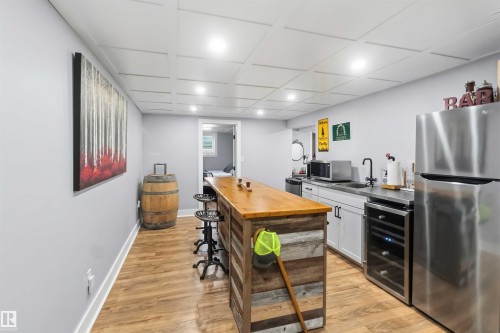Entertainment space featuring wood-finish flooring, recessed lighting, and a coffered ceiling - 11431 144 Avenue, Edmonton, AB 