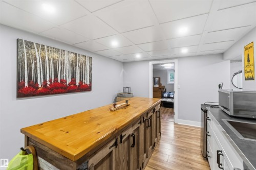 Entertainment space featuring a wood-finish flooring, recessed lighting, and a coffered ceiling - 11431 144 Avenue, Edmonton, AB 