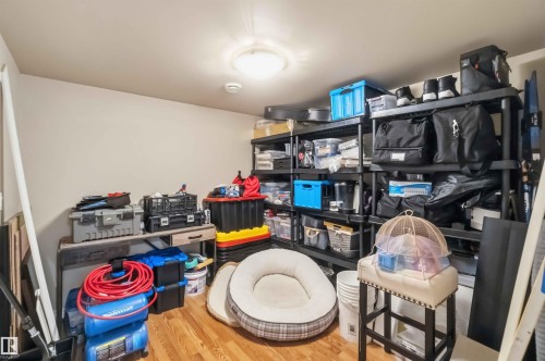 Dedicated storage area featuring wood-finish flooring, a flush-mount ceiling light, and ample shelving capacity - 11431 144 Avenue, Edmonton, AB 