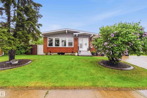 Single-story property with a red brick facade, grey siding, and a white front door - 11431 144 Avenue, Edmonton, AB 