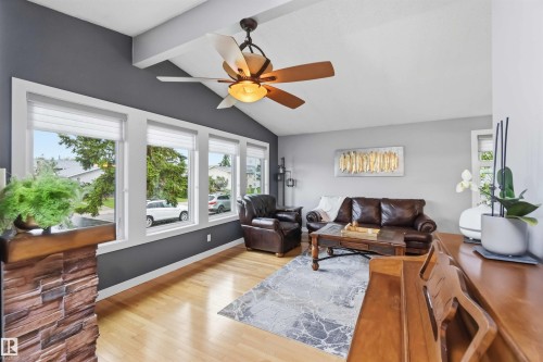 Living area featuring wood-finish flooring and a vaulted ceiling with exposed beams - 11431 144 Avenue, Edmonton, AB 