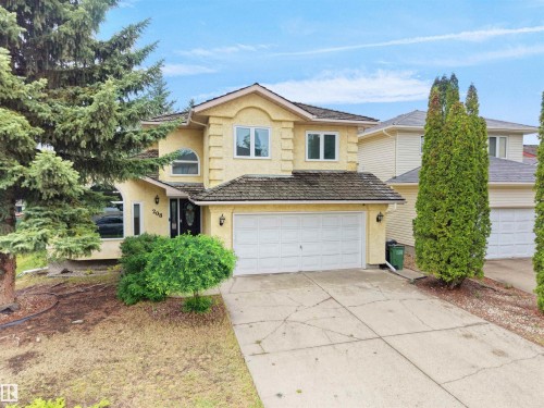 Light yellow stucco exterior with a multi-pane front door - 208 Ferguson Place, Edmonton, AB 